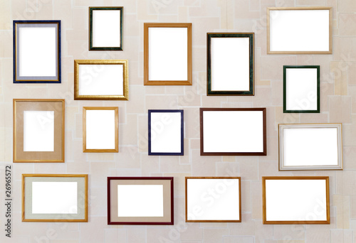 Many various photo frames  hang on a wall.