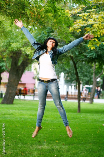 young woman jamping on a grass