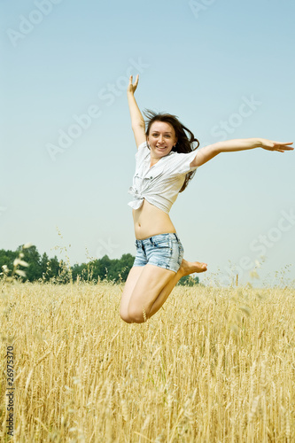 Jumping girl  at cereals field © JackF
