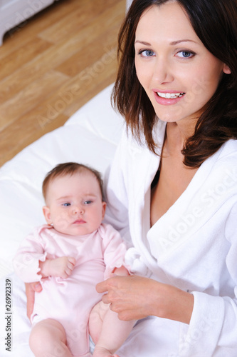 Happy mother with child sitting in bedroom