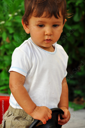 Portrait of an one years old boy in toy car