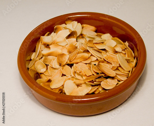 Toasted flahedalmonds in a small round terracota dish