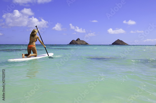 teenage girl in bikini on a paddle board in hawaii