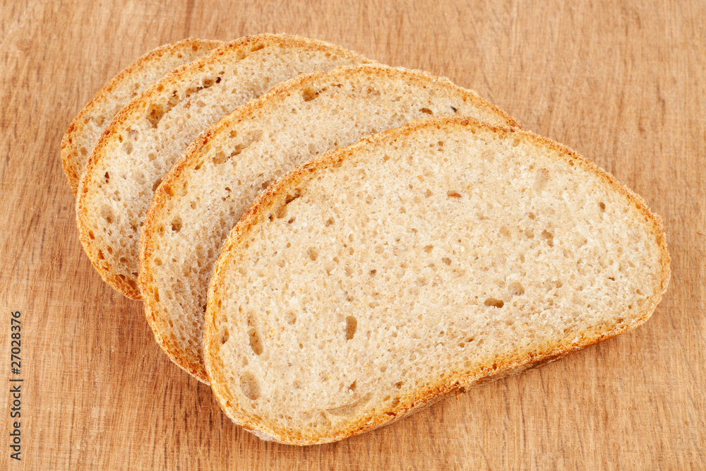 Fresh bread slices on a wooden cutting board Fresh bread slices on a wooden cutting board