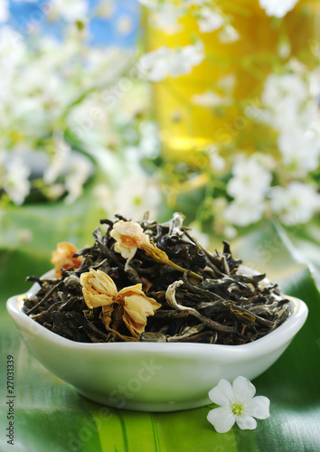 Loose green tea with jasmine flowers in a bowl