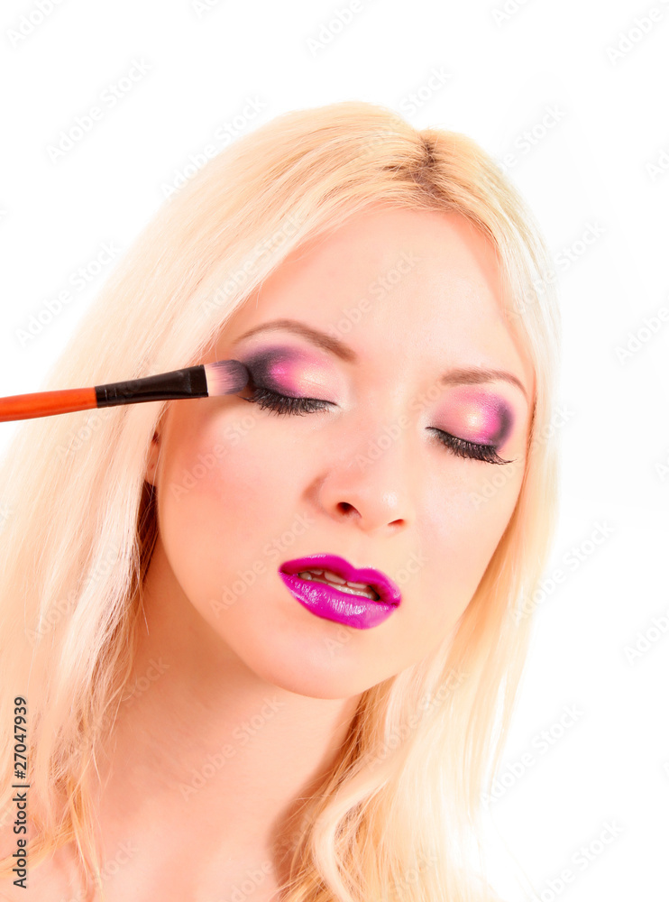 Beautiful young blonde woman with bright make-up and brush on wh Beautiful young blonde woman with bright make-up and brush on wh