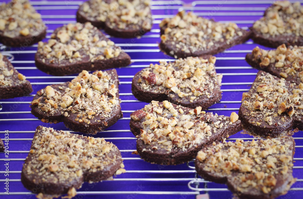 Chocolate cookies with nuts shaped as hearts cooling on a wire Chocolate cookies with nuts shaped as hearts cooling on a wire