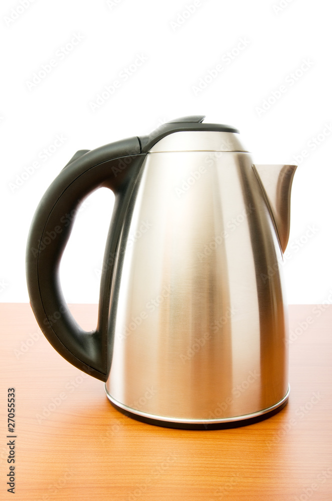 Shiny tea kettle on the wooden table