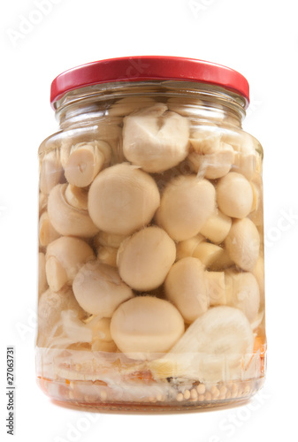 Marinaded mushrooms in a glass jar .