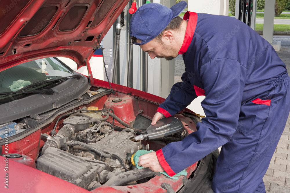 Mechanic Checking Oil Level at Gas Station Mechanic Checking Oil Level at Gas Station