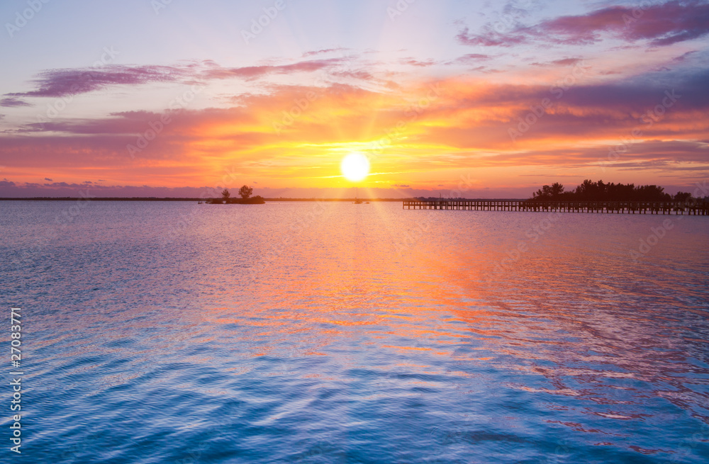 Dramatic sunrise over river pier. Indian river, Florida, USA