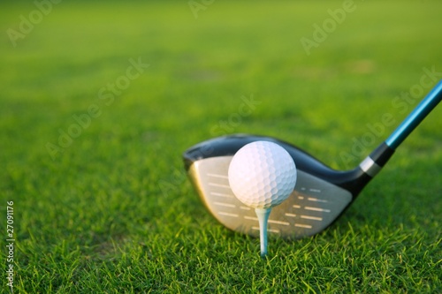 Golf tee ball club driver in green grass course