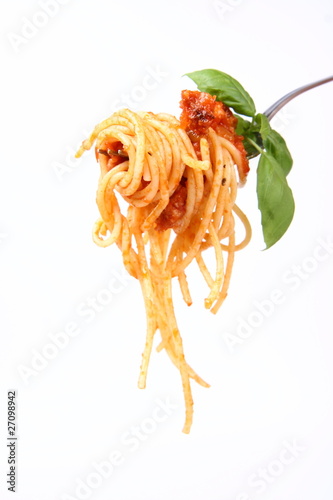 Spaghetti with sauce bolognese hanging on a fork with basil