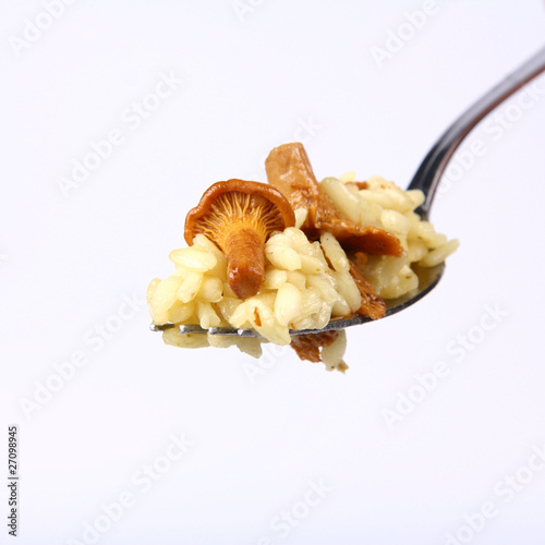 Risotto with mushrooms on a fork on white background photo