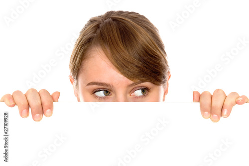 Woman peeping over a blank billboard