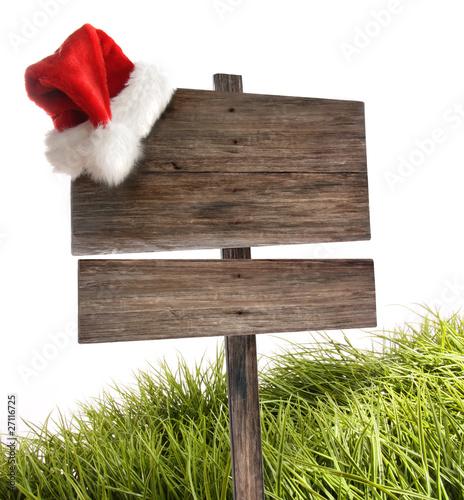 Weathered wooden sign with santa hat on white