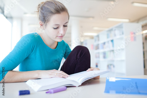 pretty young college student in a library (shallow DOF; color to