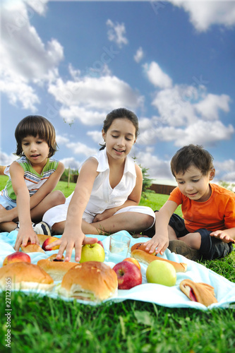 Small group of children eating together in nature  picnic