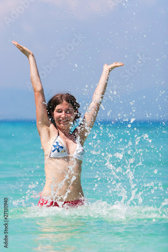 Young woman plays in water