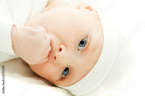 little baby boy in white hat over white