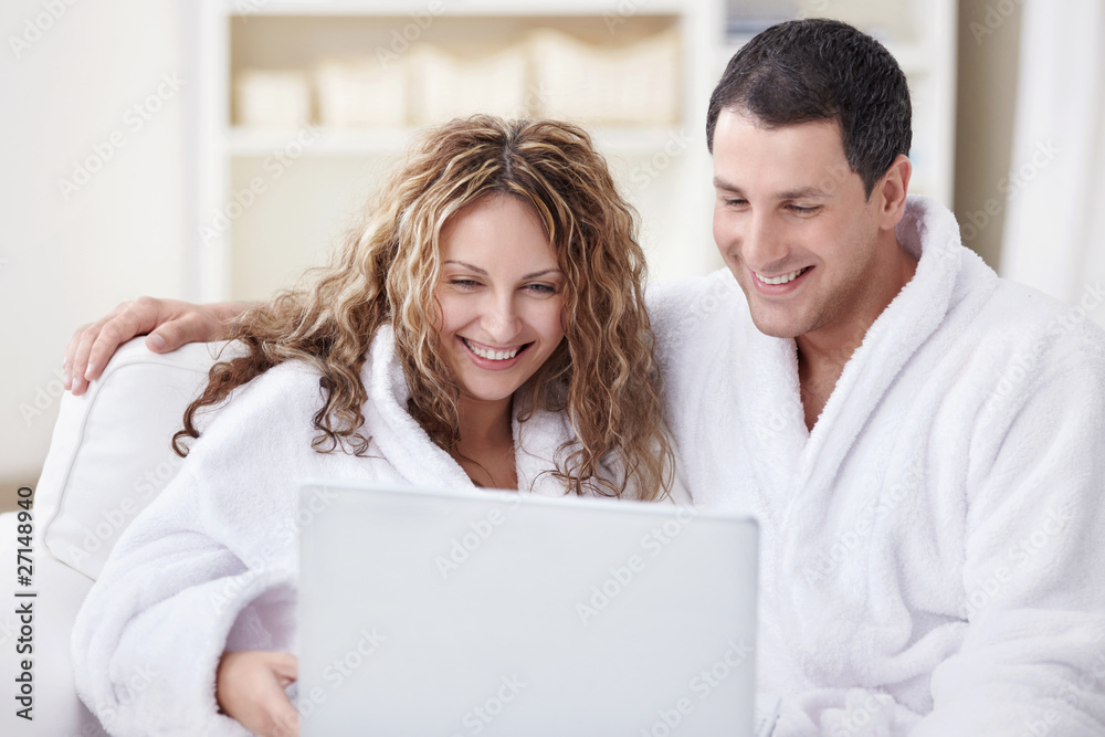 Laughing couple with laptop
