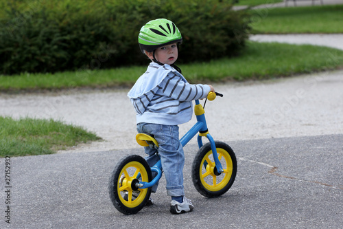 Fototapeta Naklejka Na Ścianę i Meble -  Child learning to ride on his first bike