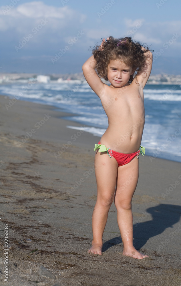 Foto Stock bambina ni riva al mare | Adobe Stock