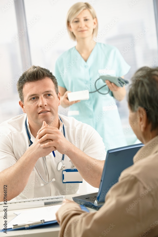 Fototapeta premium Doctor talking to elderly patient
