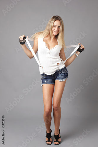 Young woman wearing denim shorts with suspenders.