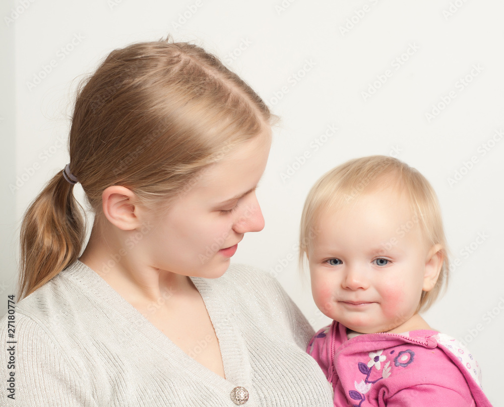 young mother holding toddler daughter in pink young mother holding toddler daughter in pink