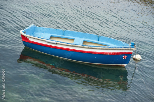 Small, blue rowboat moored in a marina © Yory Frenklakh