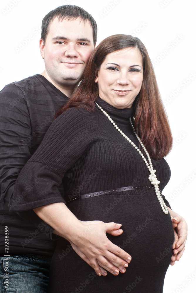 Happy pregnant wife with husband hugging her belly Happy pregnant wife with husband hugging her belly