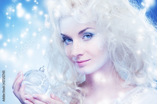 Beautiful snow queen with a christmas ball ..