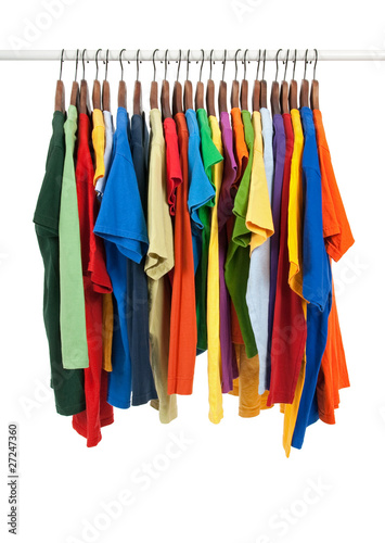 Variety of multicolored shirts on wooden hangers