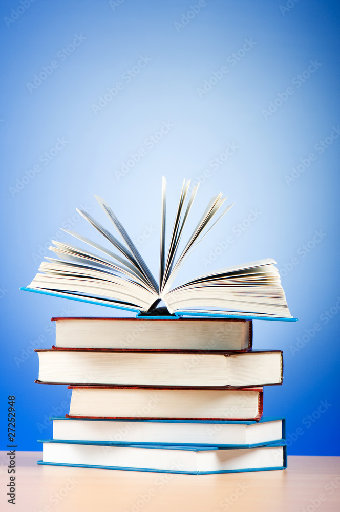 Fototapeta premium Stack of text books against gradient background