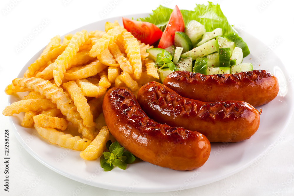 Grilled sausages, French fries and vegetables Grilled sausages, French fries and vegetables