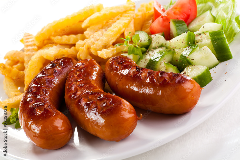 Grilled sausages, French fries and vegetables Grilled sausages, French fries and vegetables