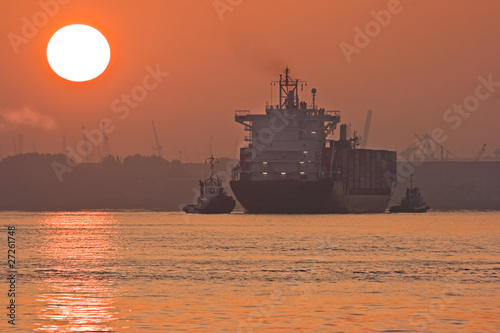 Red sunrise in the mist with ships