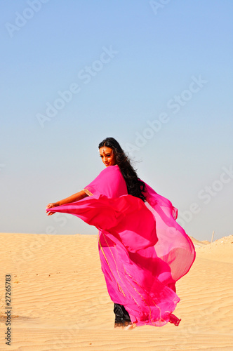 Beautiful young woman  dancing in arabic desert