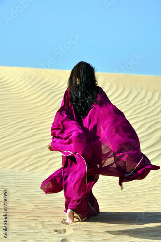 Arabic brunette woman walking through the desert