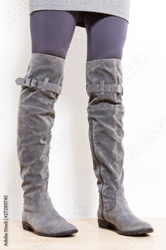 detail of standing woman wearing fashionable gray boots