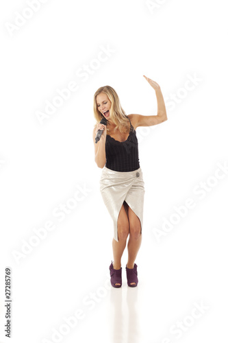 Young woman with microphone dancing and singing