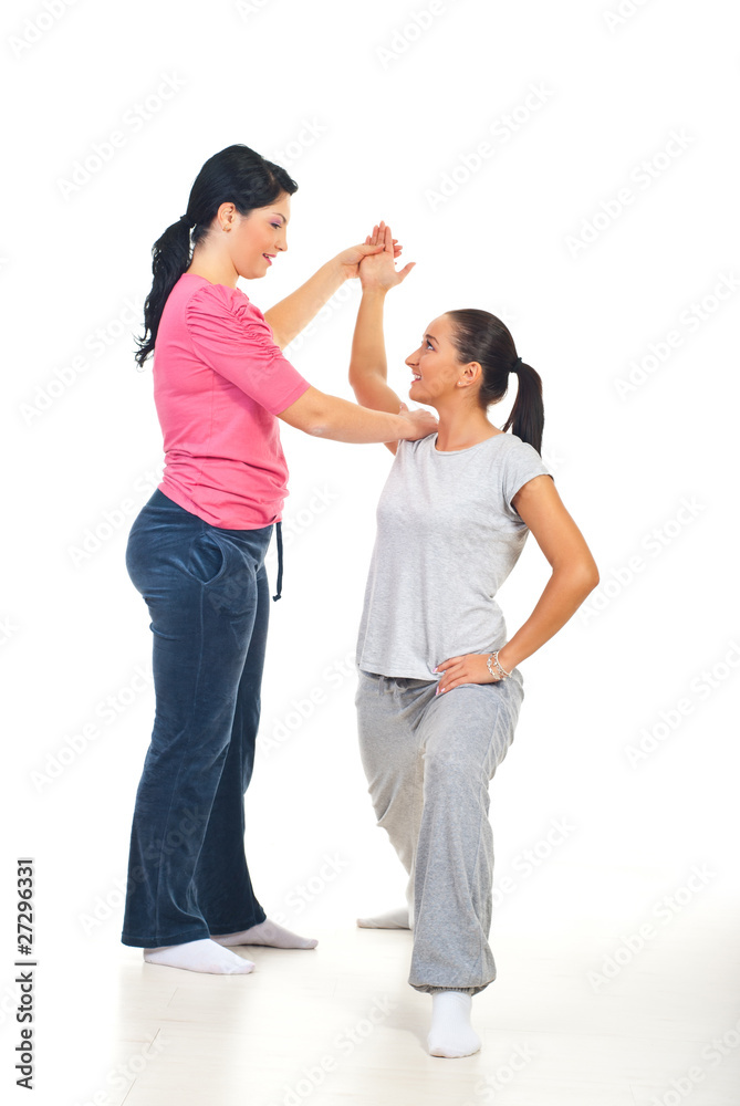 Fitness instructor assisting woman Fitness instructor assisting woman