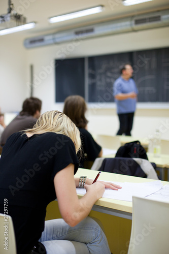 young pretty female college student sitting in a classroom full