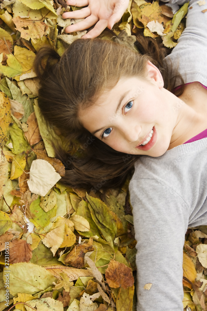 Portrait of teenage girl lying down with leaves around. Portrait of teenage girl lying down with leaves around.