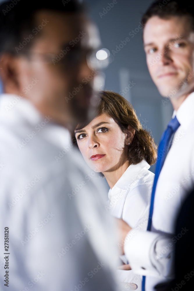 Obraz premium Woman looking between two businessmen