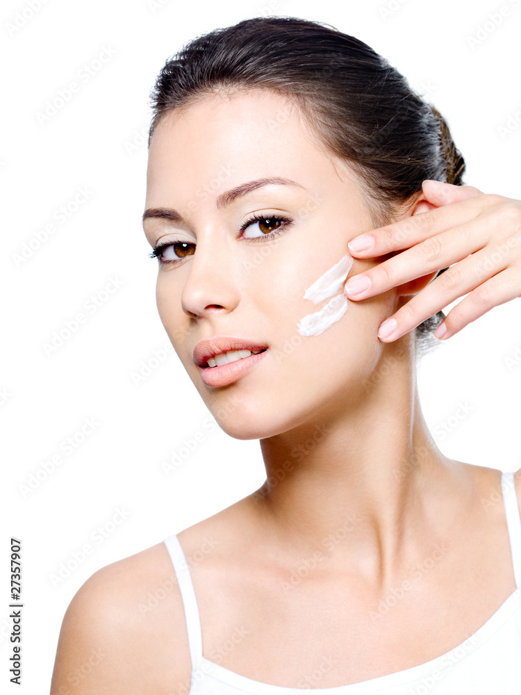 Woman applying cream on her face