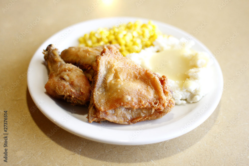 Fried chicken with a side of mashed potatoes and corn
