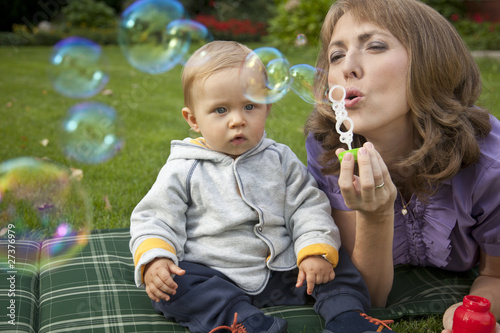 Mother and baby playing bubbles in the garden