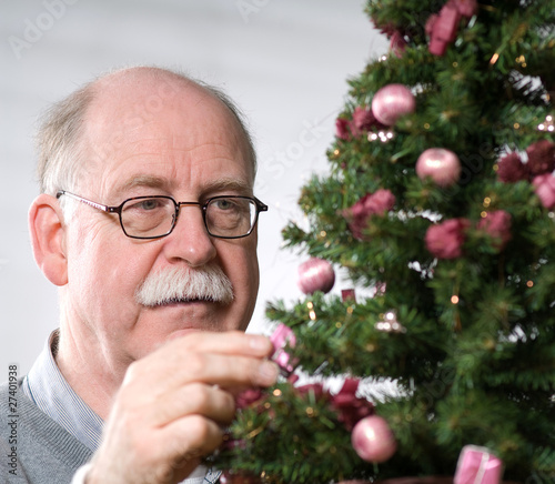 Senior man decorate Christmas tree